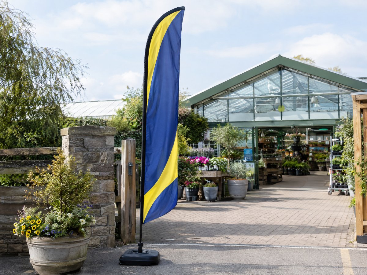 Beachflag Quill vor einem Gartencenter